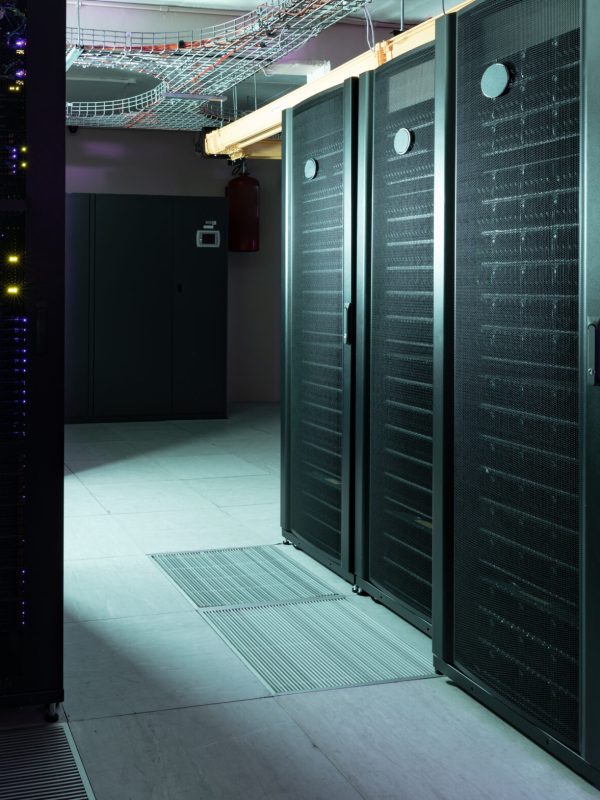 Data center with multiple rows of fully operational server racks. modern cloud computing technology concept.